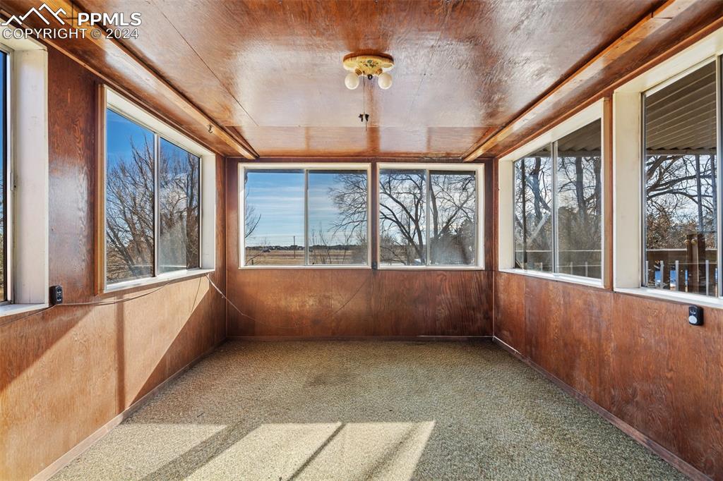 Bonus sunroom with plenty of natural light and wooden walls & ceiling