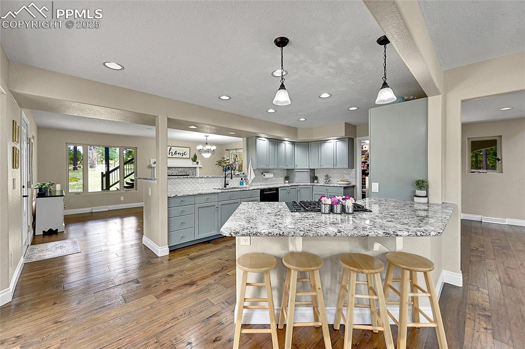 Kitchen featuring a kitchen breakfast bar,  solid wood cabinetry, granite countertops and decorative backsplash