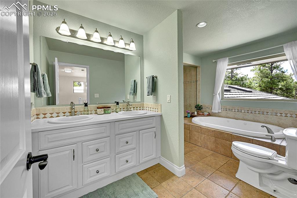 Bathroom with double vanity, jacuzzi tub and enclosed steam shower