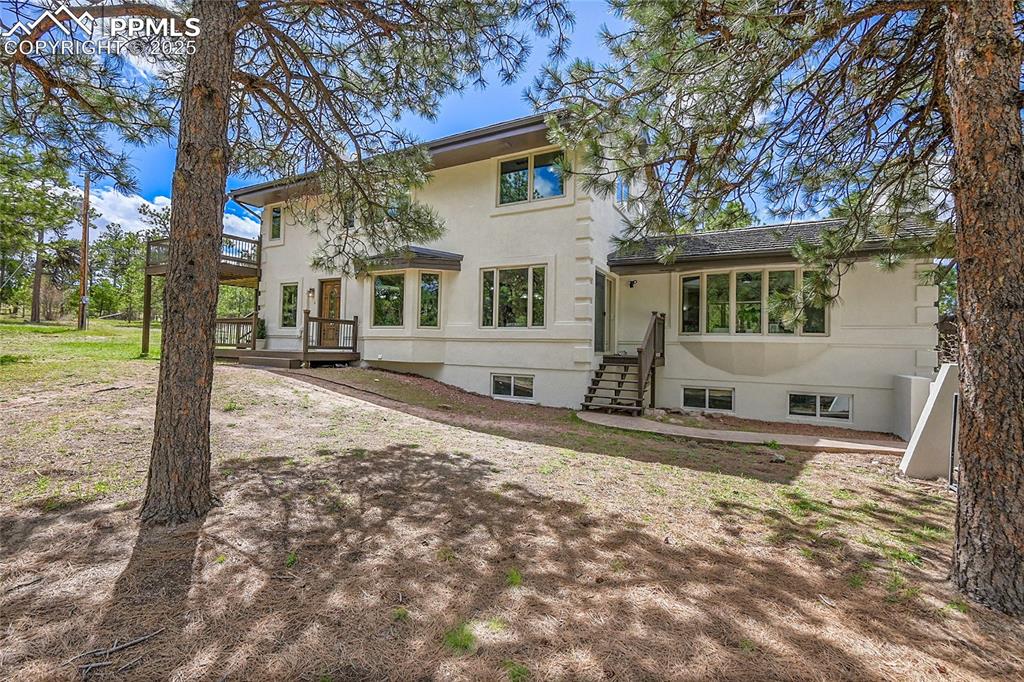 View of front of property with a wooden deck and stucco siding