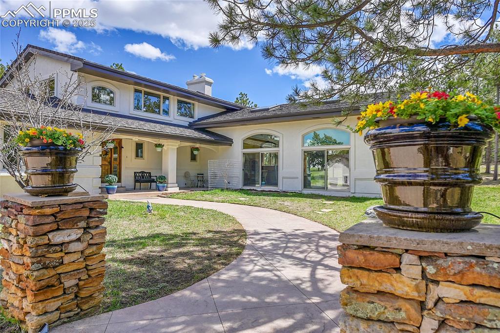 Front entry stairs and stamped concrete pathway leading to oversized covered porch 