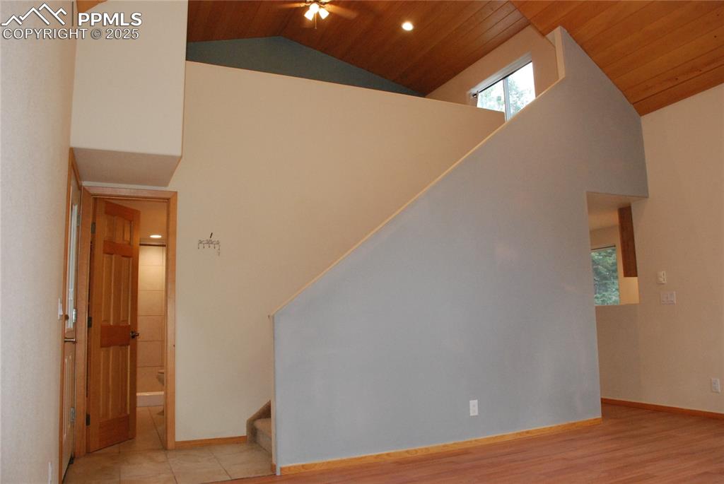 Looking back from the Living Room, you can see the tiled entry, full bath, and staircase leading to Loft... all accented with the wood cathedral ceilings.