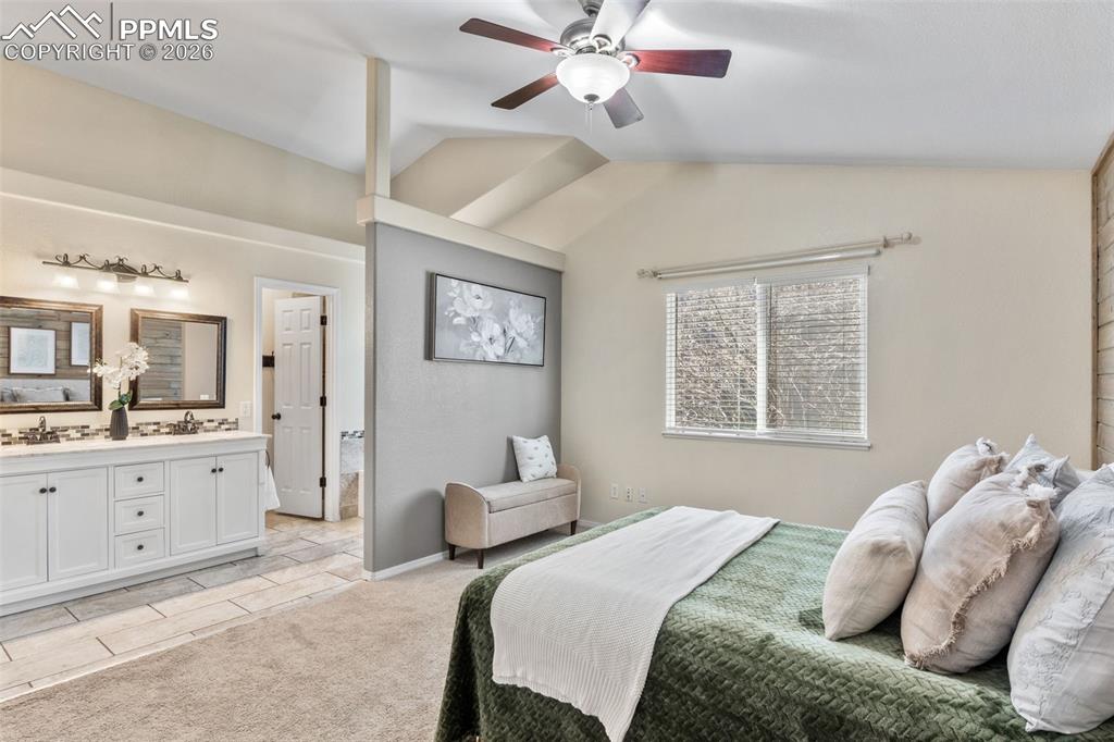 Bedroom with lofted ceiling, a ceiling fan, light tile patterned floors, and light colored carpet