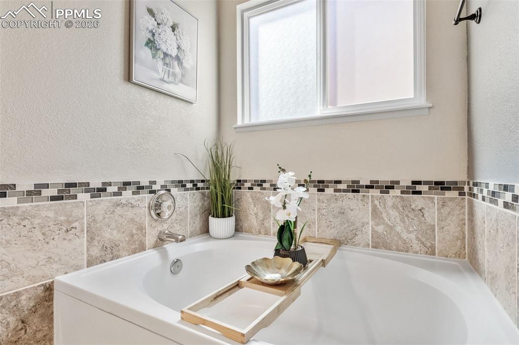 Bathroom with a bath and a textured wall