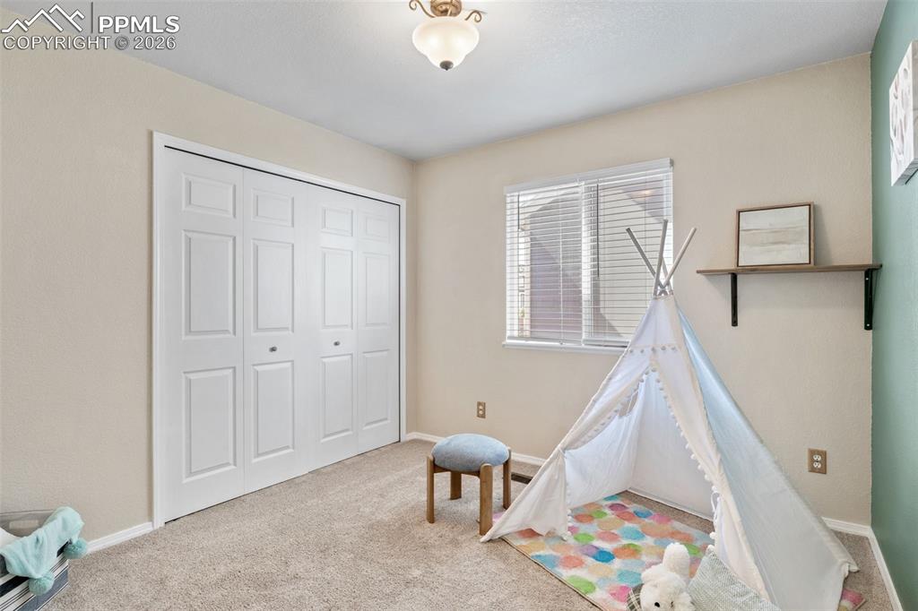 Recreation room featuring carpet floors and baseboards