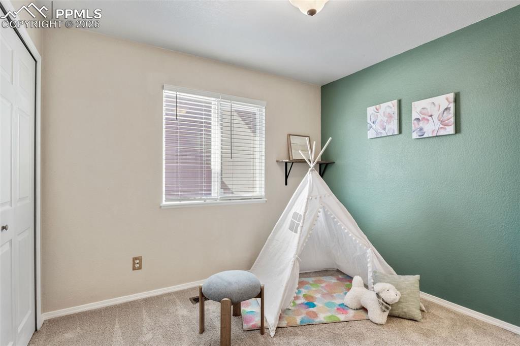 Recreation room featuring light carpet and baseboards