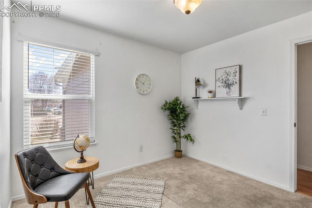 Living area with light carpet and baseboards