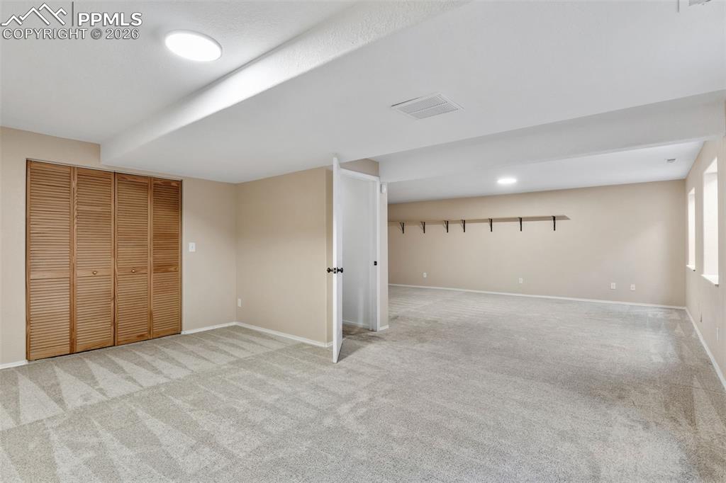 Finished below grade area with light colored carpet and baseboards