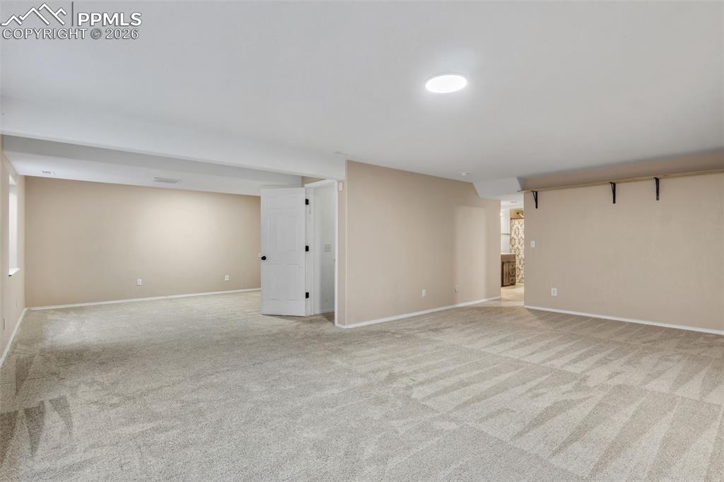 Finished basement featuring light colored carpet and baseboards