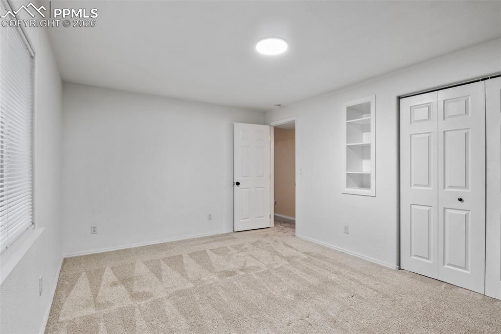 Unfurnished bedroom with light carpet and a closet