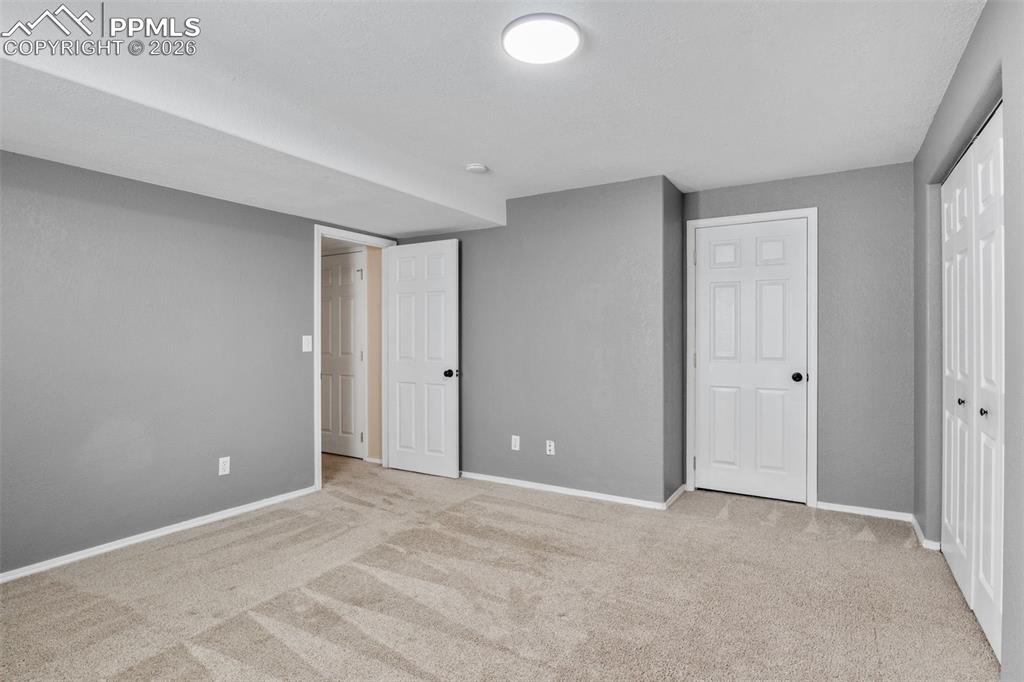 Unfurnished bedroom with light carpet and a closet
