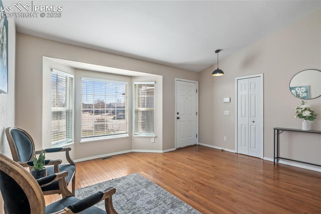 Foyer featuring light wood-style flooring and vaulted ceiling