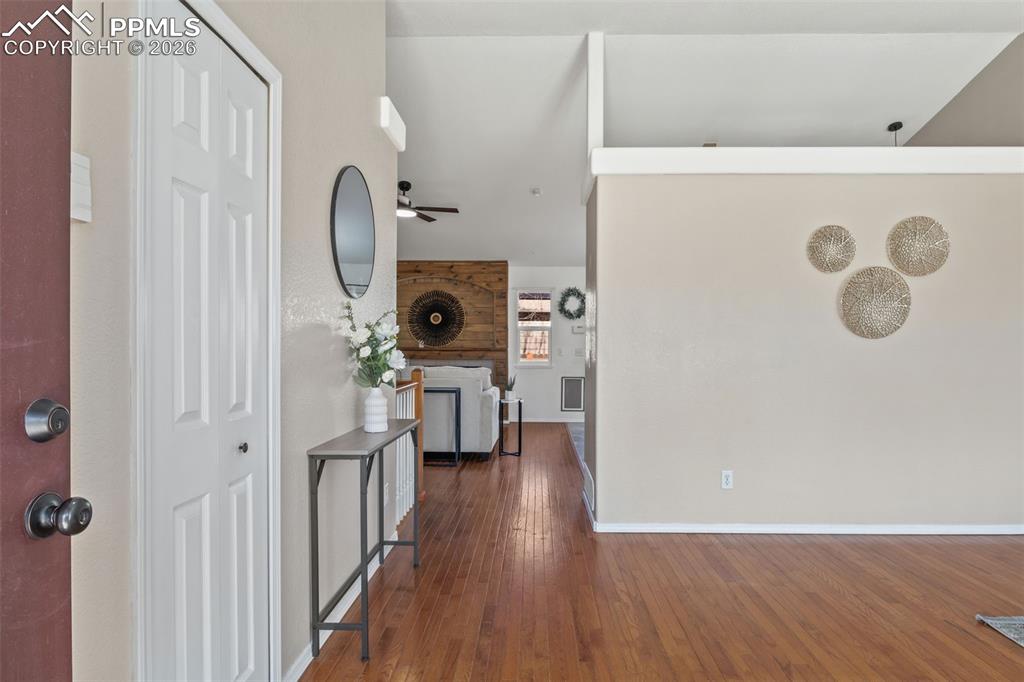 Entryway with dark wood-style floors and a ceiling fan