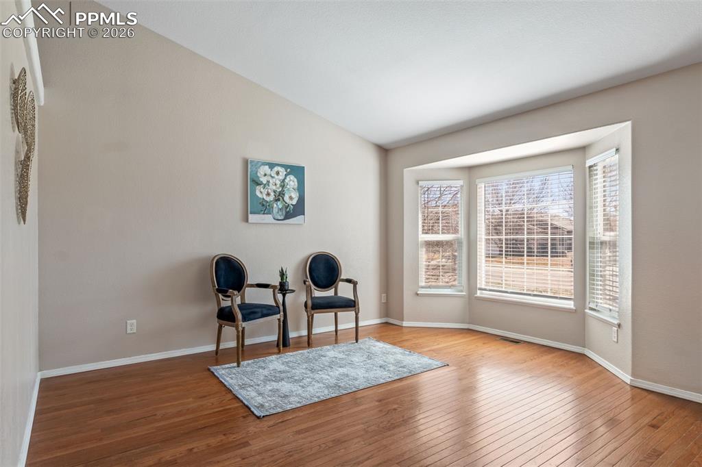 Sitting room with hardwood / wood-style flooring and vaulted ceiling