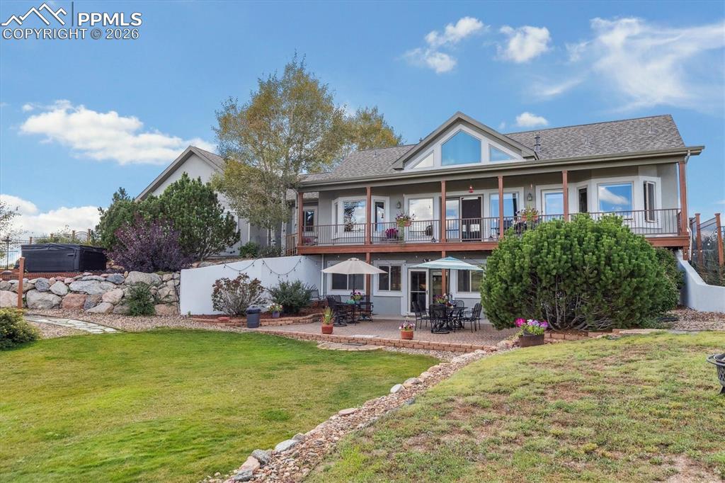 Back of property featuring a patio, a balcony, and stucco siding