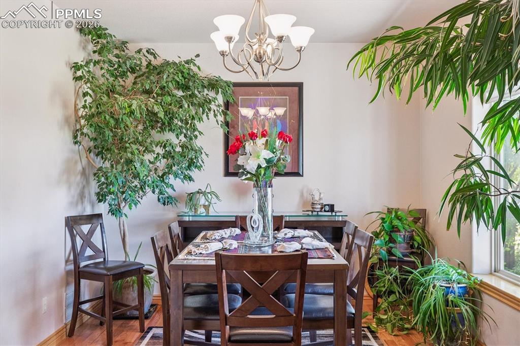 Dining space with a chandelier and wood finished floors