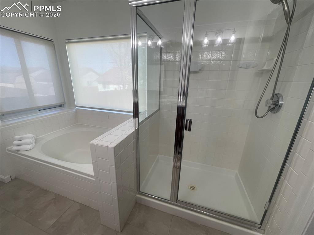 Bathroom with a shower stall and a bath