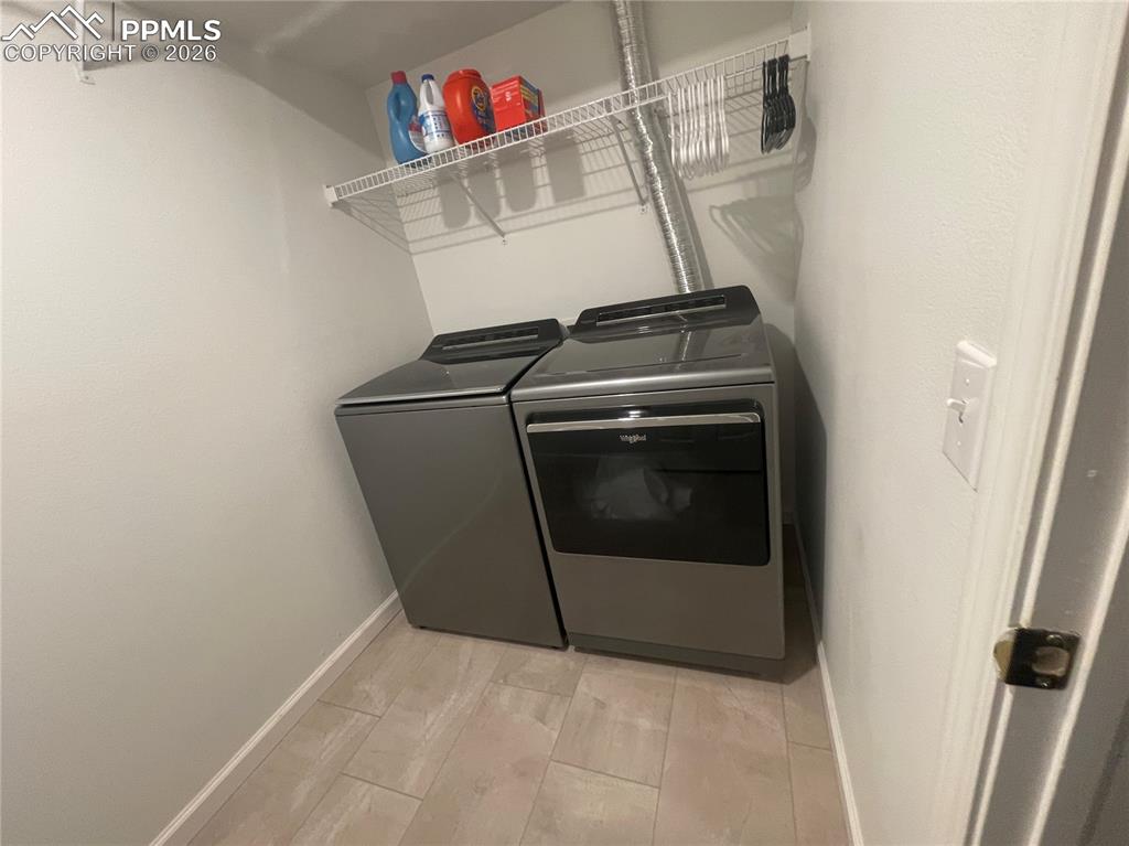 Laundry area with separate washer and dryer and light wood finished floors