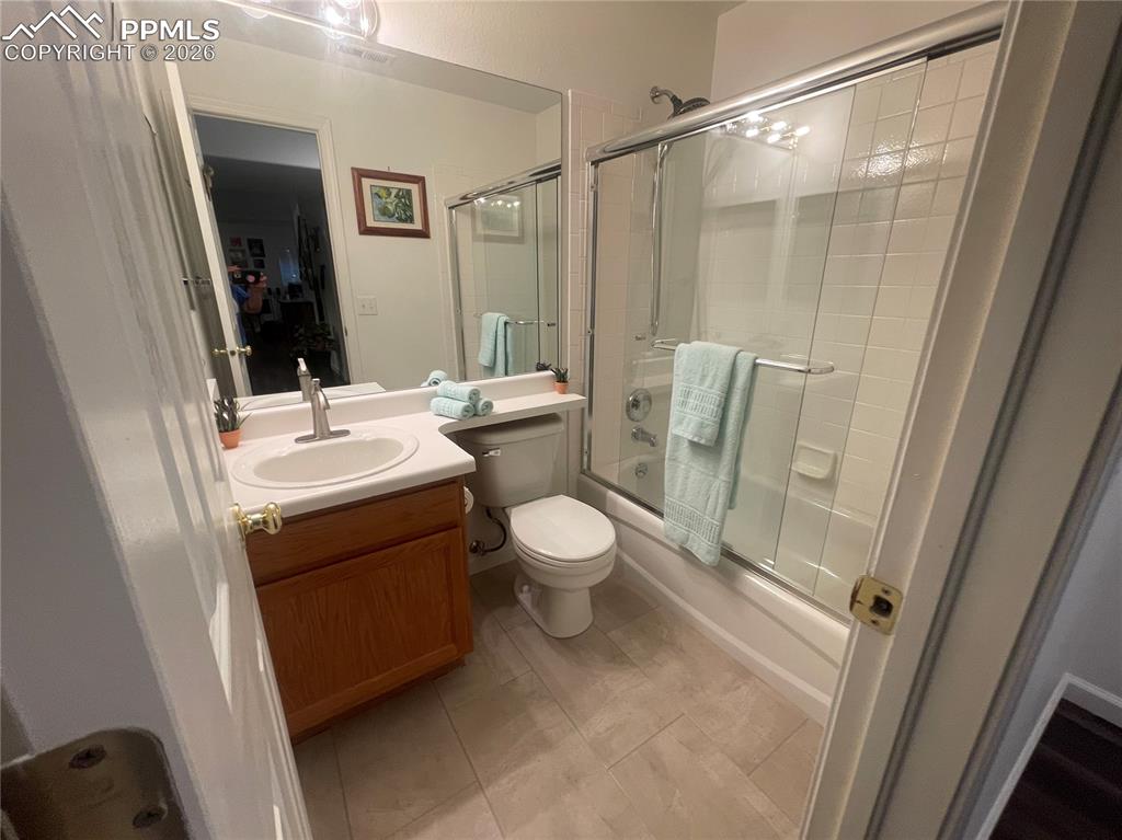 Full bathroom featuring vanity, enclosed tub / shower combo, and light tile patterned floors