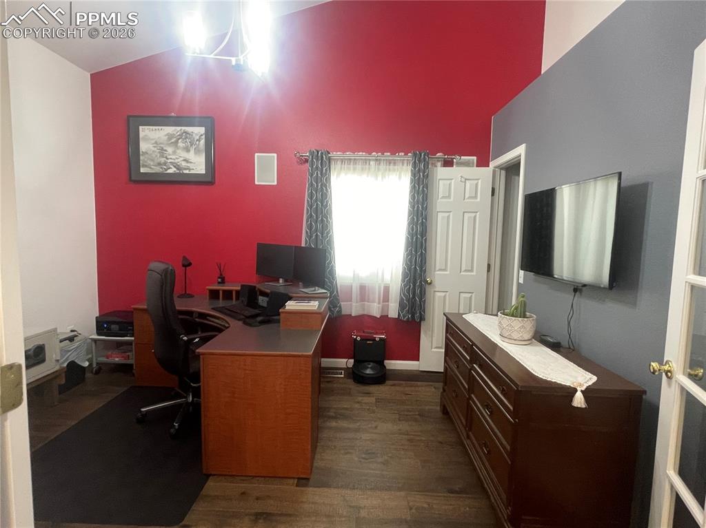Office area featuring dark wood finished floors and lofted ceiling