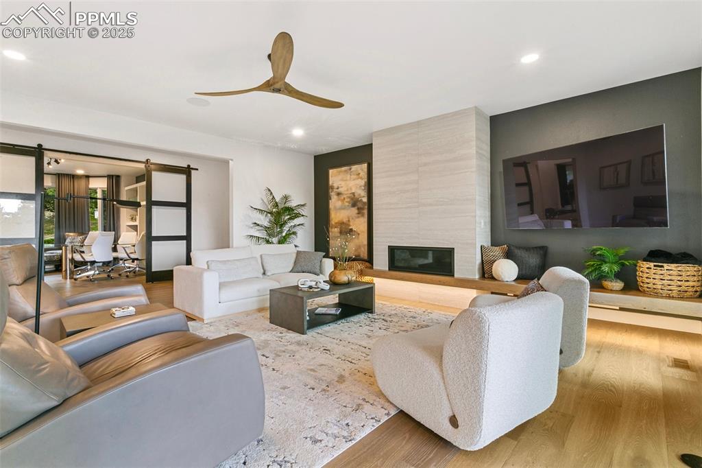 A Floating wood hearth grounds the focal point of the Great Room. Glass barn doors allow light to flow from the study.