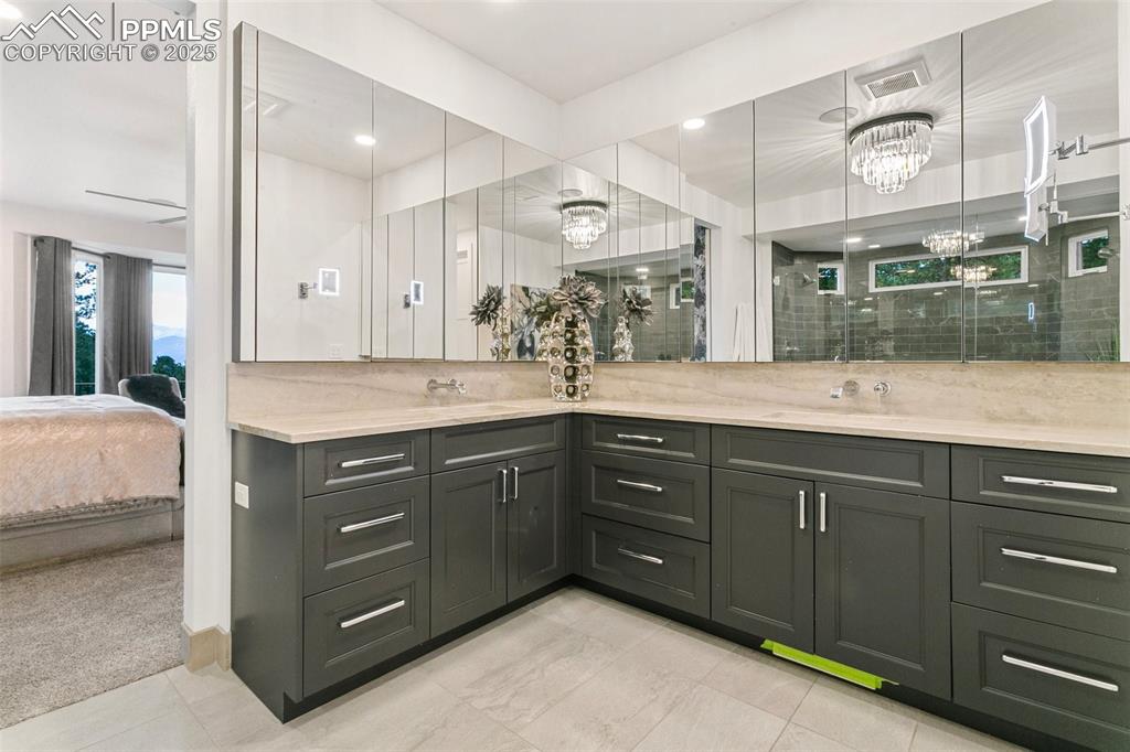 His and Hers vanities with wall mounted faucets and additional storage behind the mirrors
