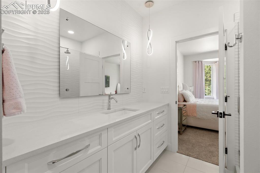 Expanded vanity in the Upper Junior Ensuite with custom tile and lighting fixtures.