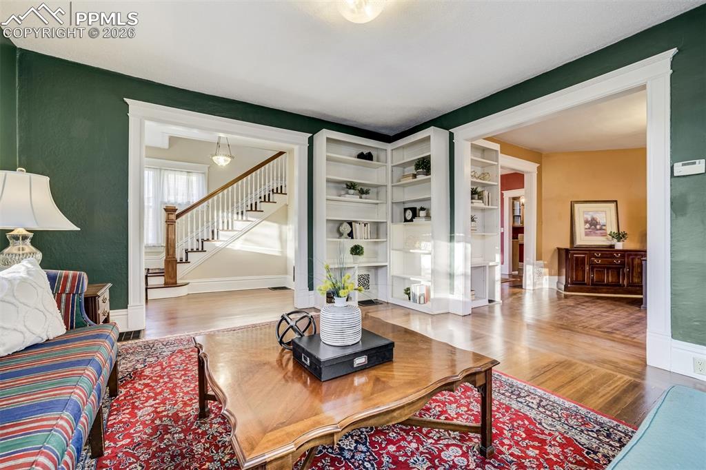 Living room provides built in shelving and opens to family room and entry