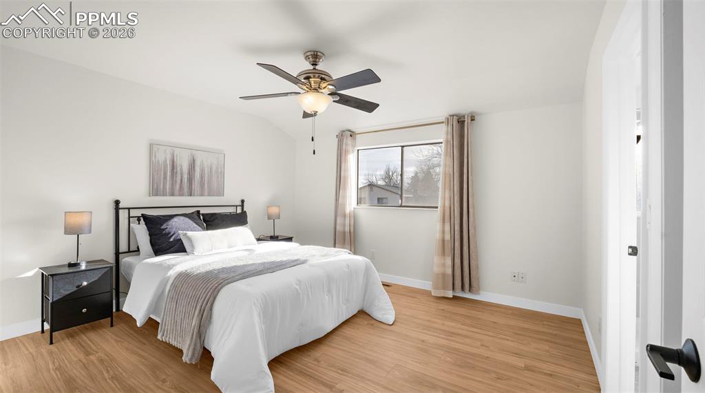 Bedroom featuring light wood finished floors, ceiling fan, and lofted ceiling