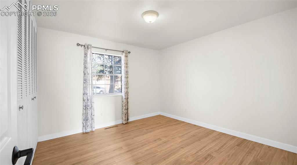 Spare room with baseboards and light wood-style floors