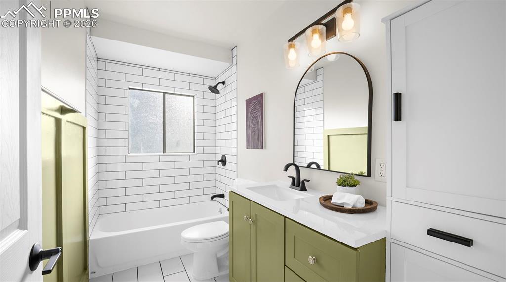 Bathroom featuring vanity,  shower combination, and light tile patterned flooring