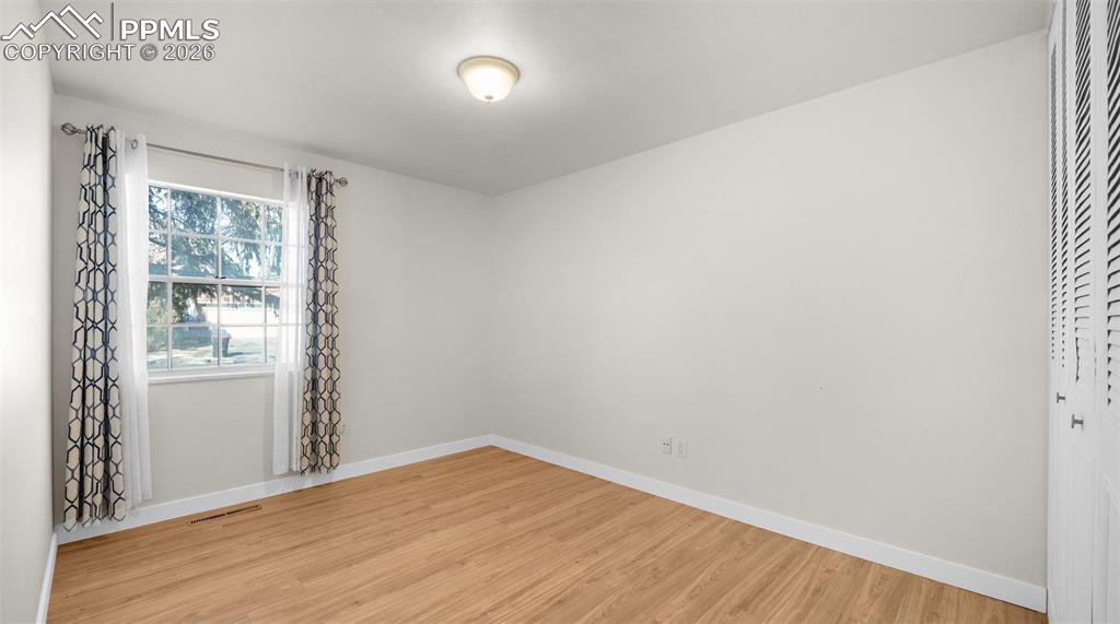 Spare room featuring light wood-style floors and baseboards