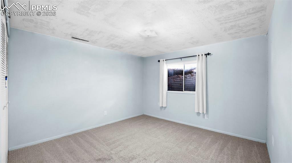 Unfurnished room featuring carpet and baseboards