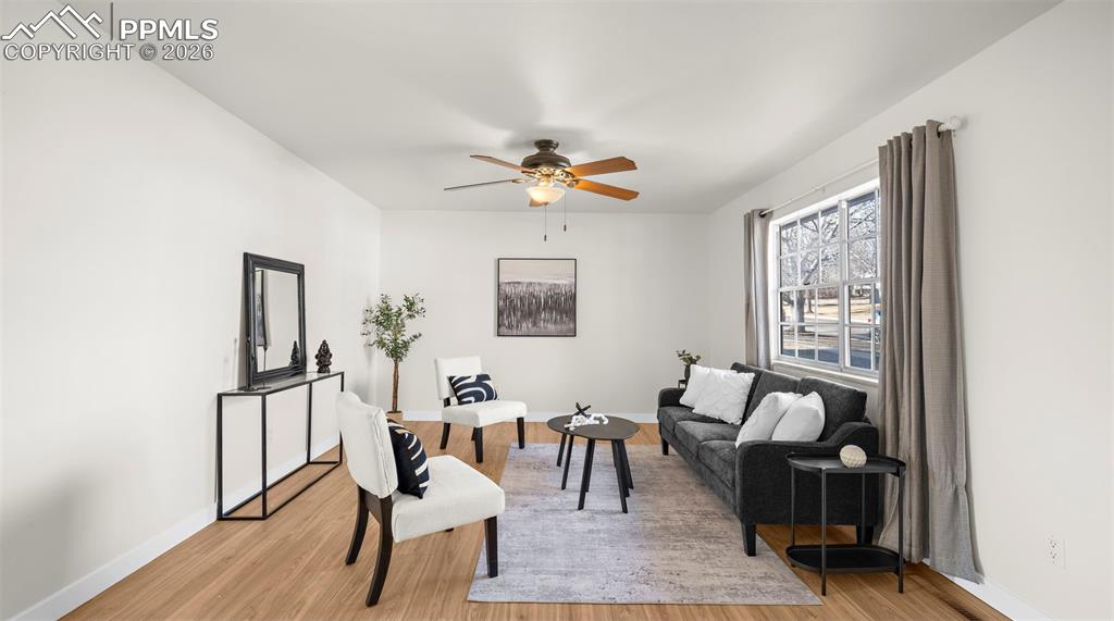 Living room featuring light wood-style flooring and a ceiling fan