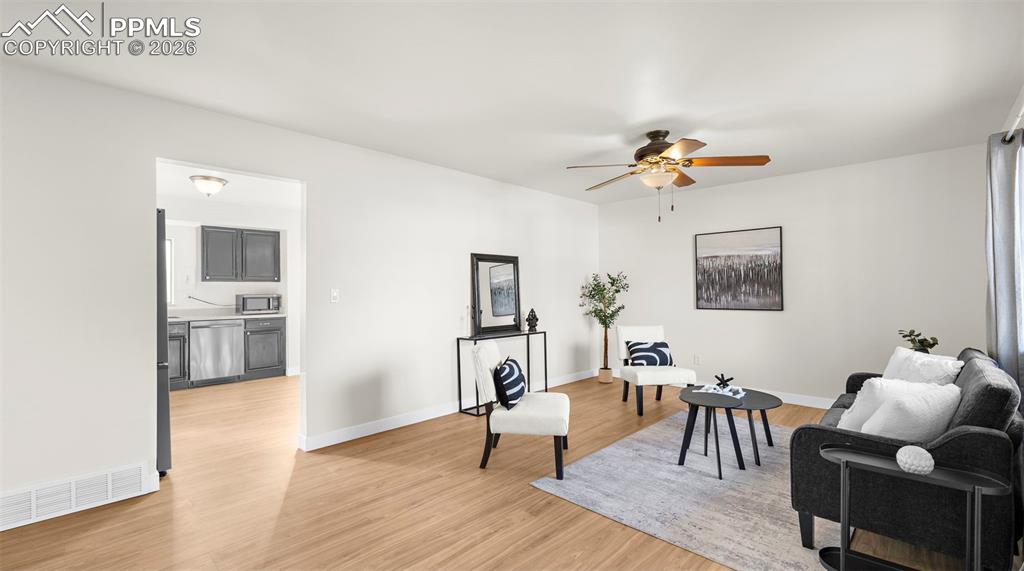 Living area featuring light wood-type flooring and a ceiling fan
