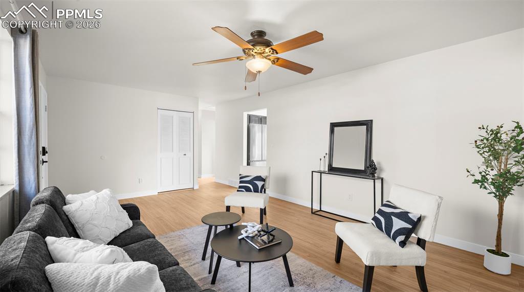 Living room with light wood-style floors and a ceiling fan