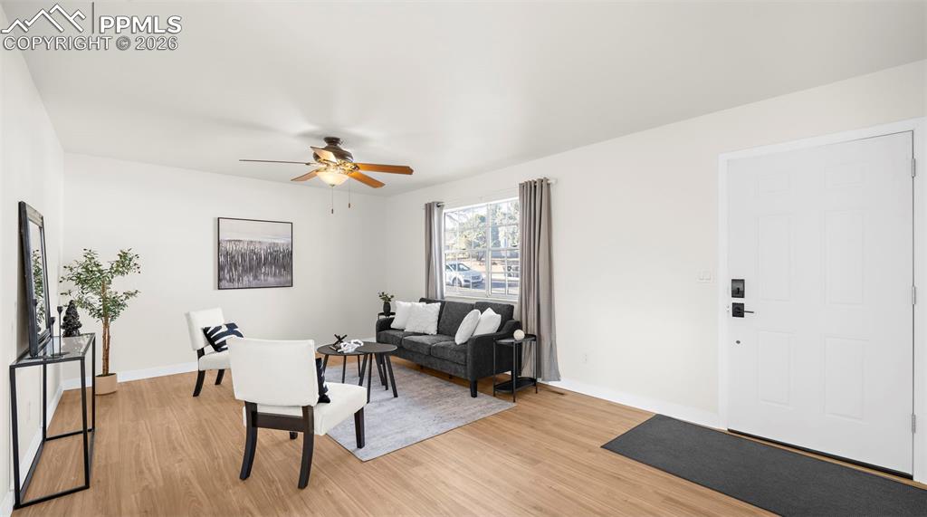 Living area featuring a ceiling fan and light wood finished floors