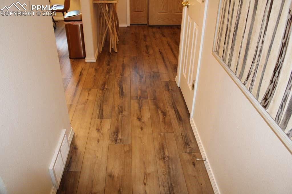 Hallway featuring wood-type flooring and baseboards