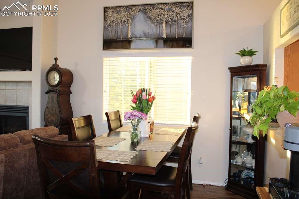 Dining area featuring dark wood-type flooring and a tile fireplace