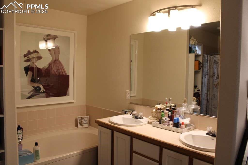 Full bathroom featuring double vanity and a garden tub