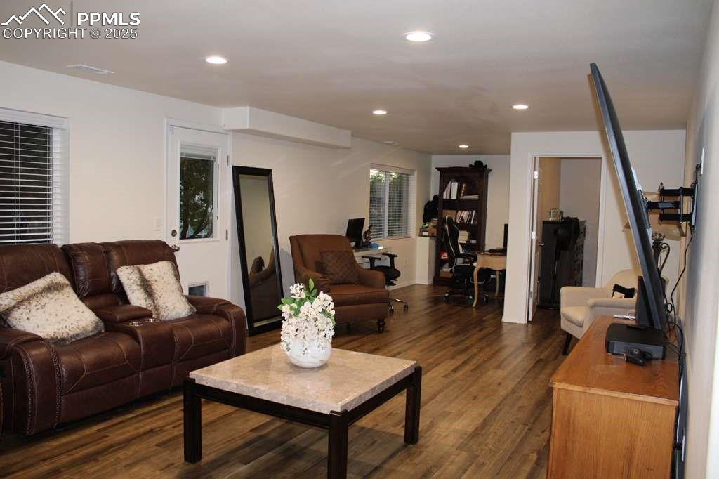 Living room with dark wood-style flooring, an office area, and recessed lighting