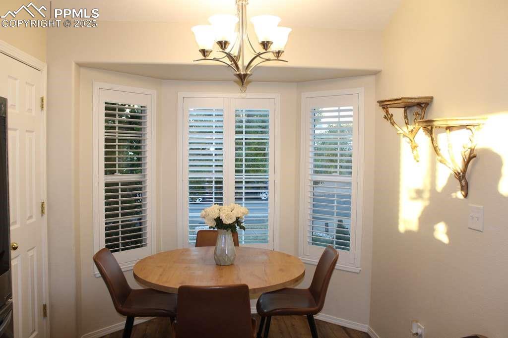 Dining room with dark wood finished floors and a chandelier