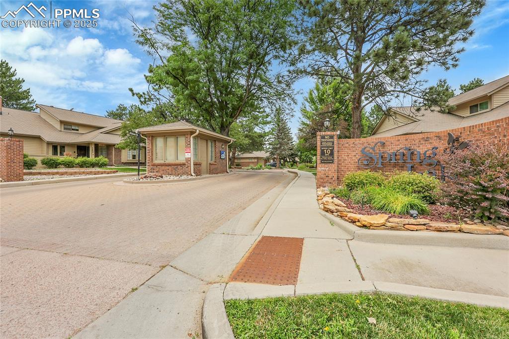 View of street featuring curbs, sidewalks, and a gated entry