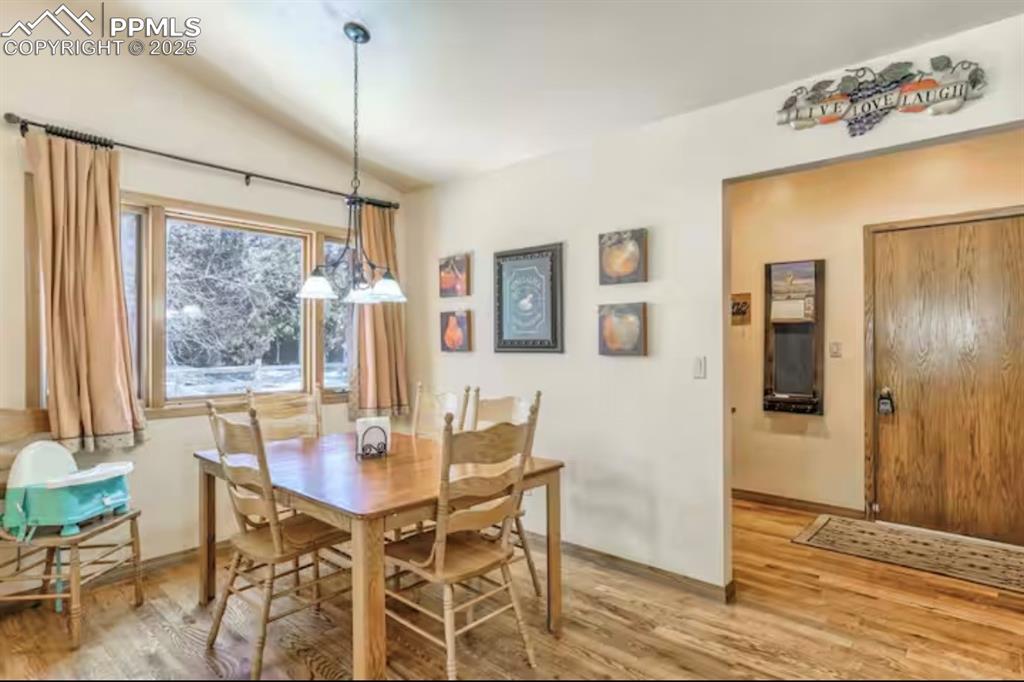 Dining room with light wood-style floors and lofted ceiling