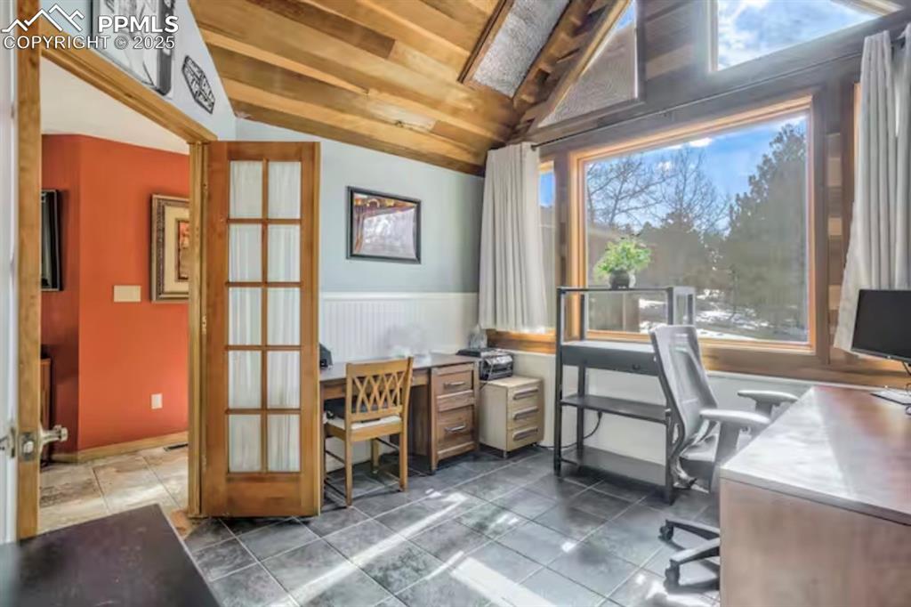 Office area with vaulted ceiling, wood ceiling, and a wainscoted wall