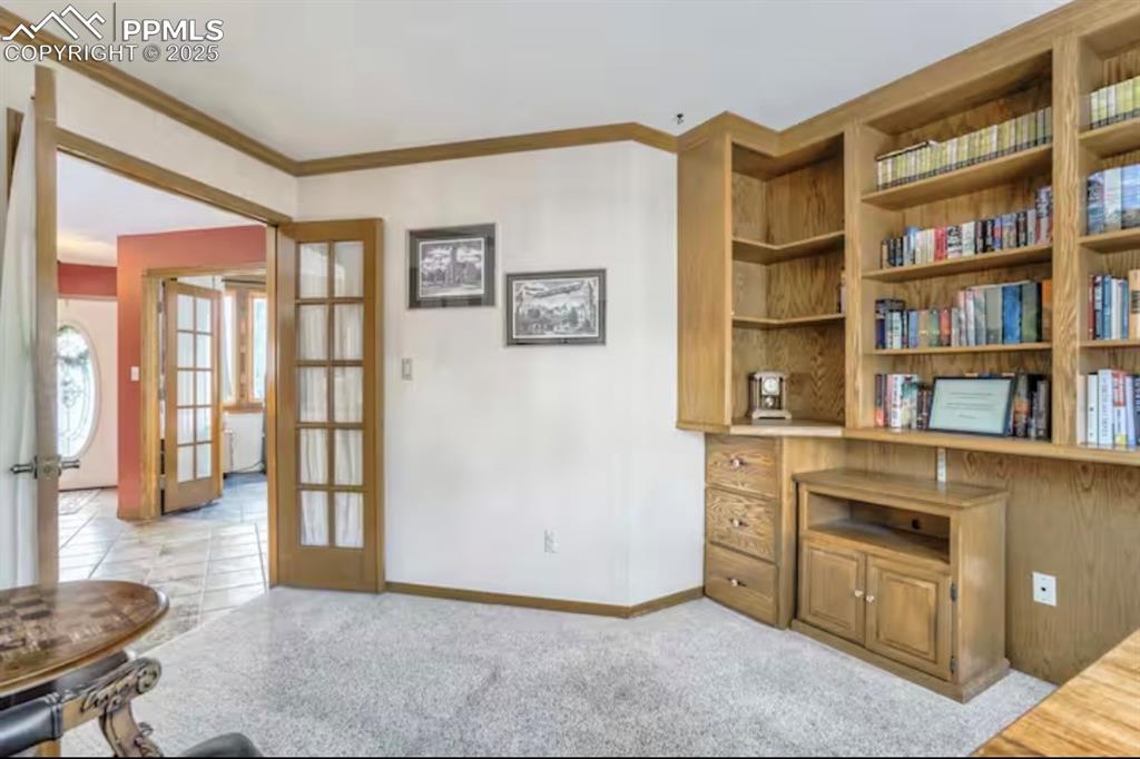 Office featuring ornamental molding, built in shelves, and french doors