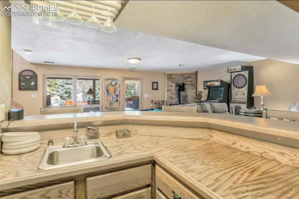 Kitchen with light countertops, a textured ceiling, and open floor plan