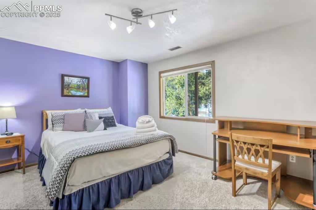 Carpeted bedroom featuring an office area