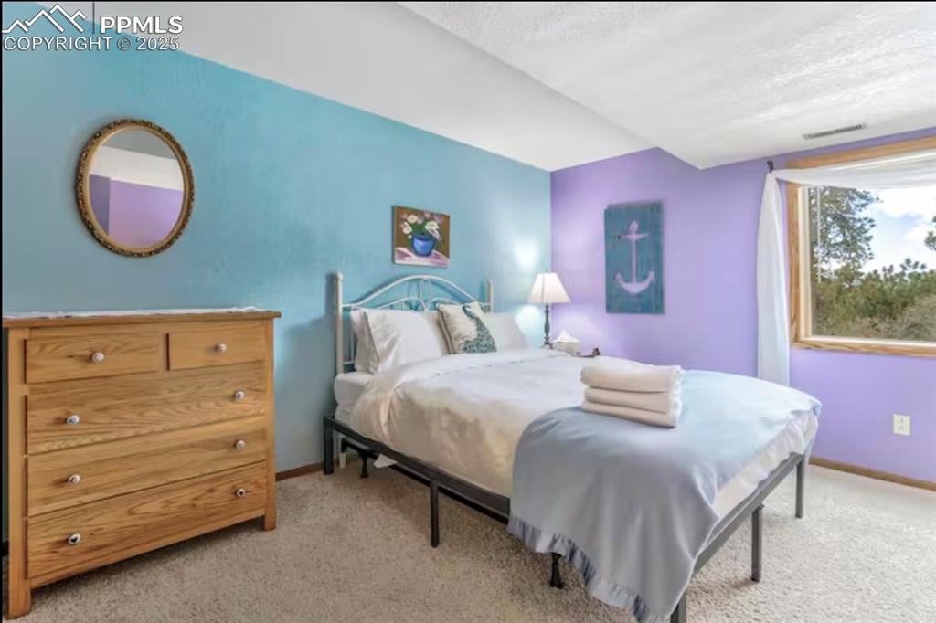 Bedroom featuring light carpet and a textured ceiling