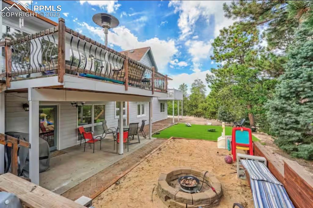 Back of property featuring a patio and a fire pit